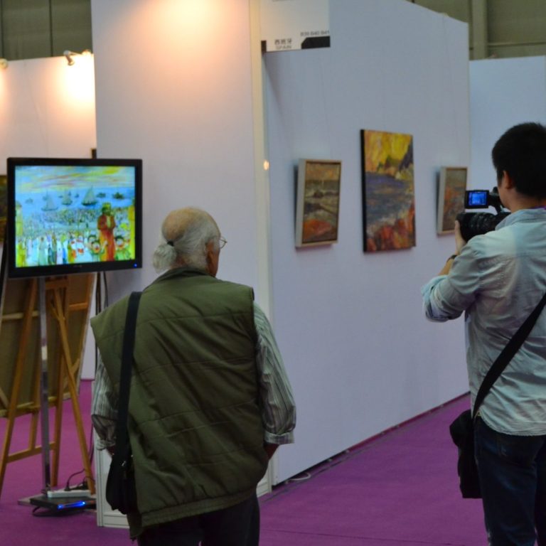 Visitantes observando obras de arte en una galería, en un ambiente cultural.